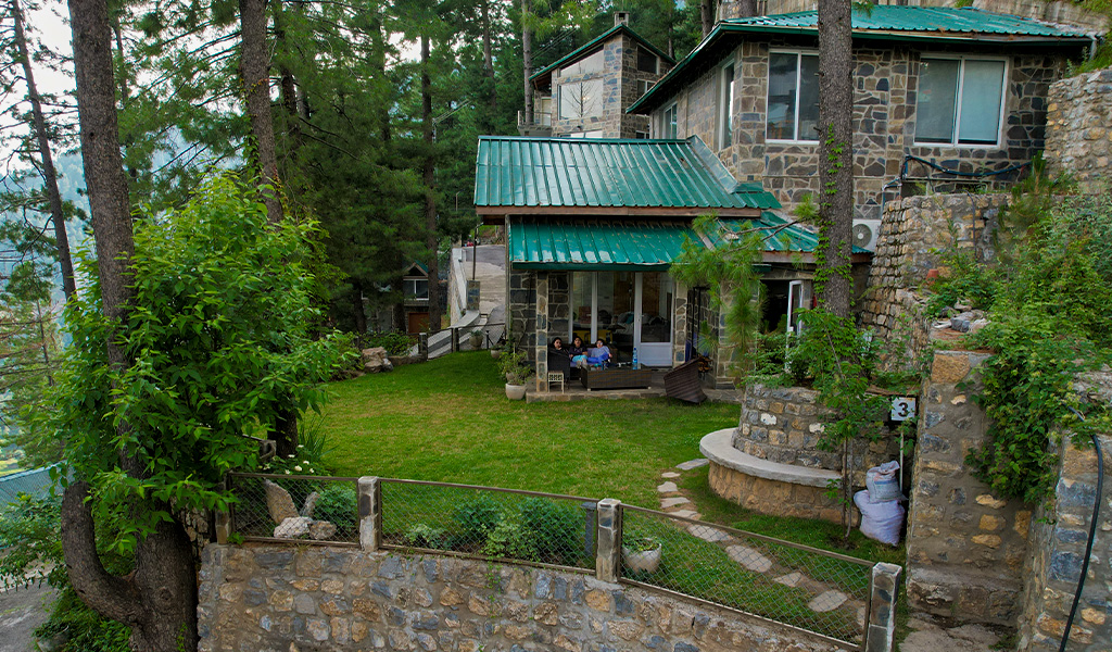 Luxury homes in Changla Gali surrounded by pine trees with stone architecture and green lawn