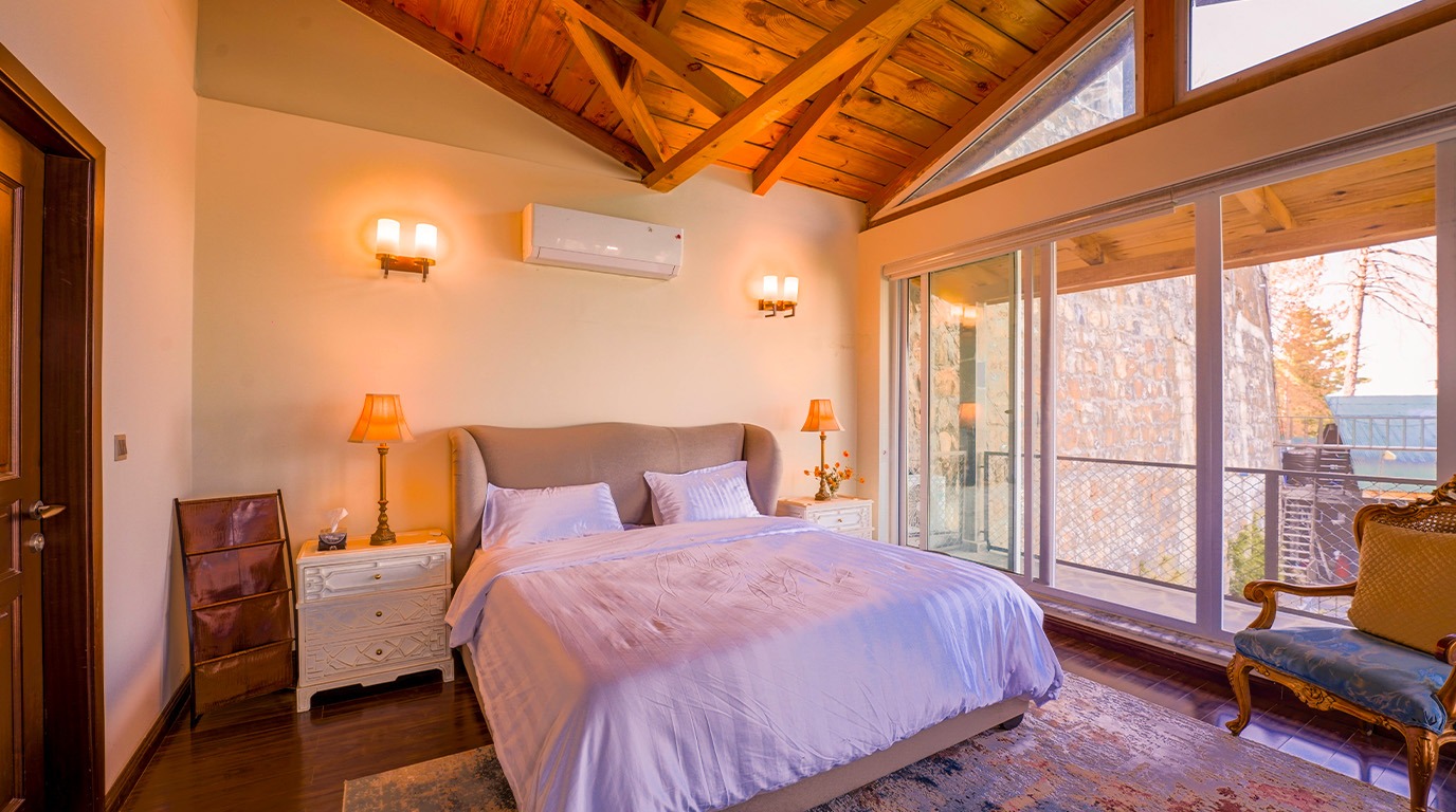 Fully furnished home in Galiyat — master bedroom with built-in wardrobe, king bed, and wood flooring — Blue Pine Mountain Homes